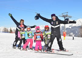 Kids and ski instructors having fun in Plan de Corones during one of the kids ski lessons for all levels.
