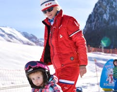 A child learns the basics of skiing with his ESF Ceillac instructor during kids ski lessons for beginners. 