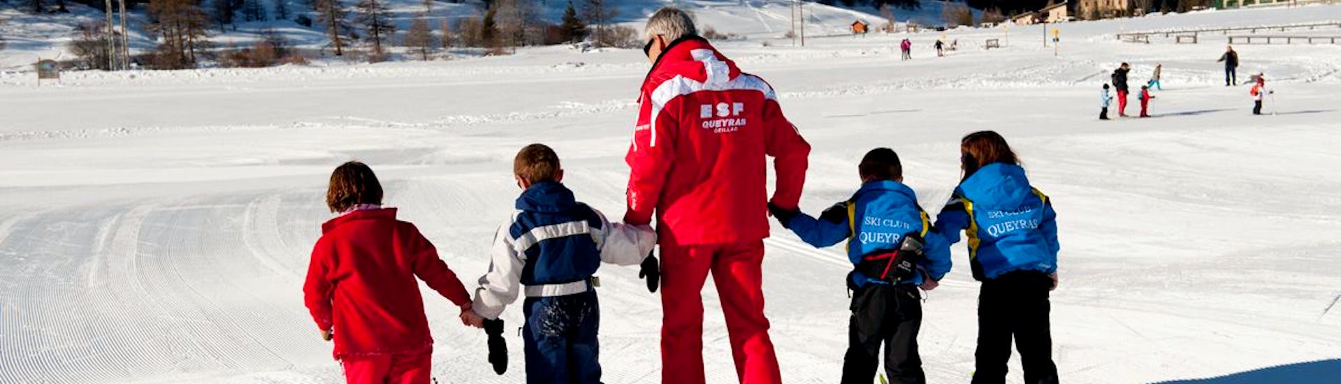 Un moniteur de l'ESF Ceillac guide des enfants pour leurs premiers pas en ski pendant un cours de ski enfants pour débutants. 