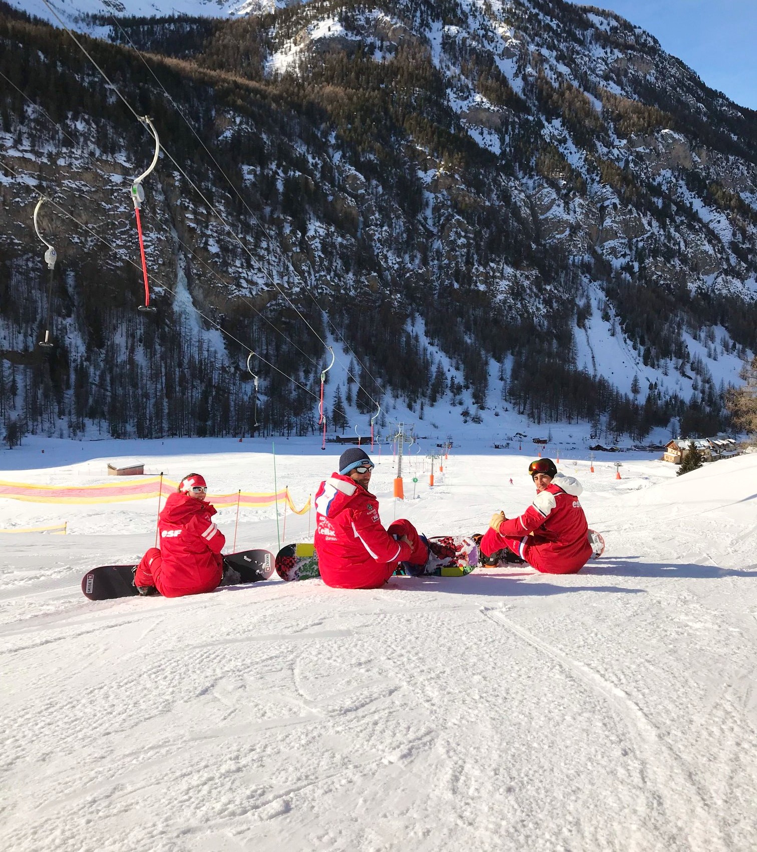 Instructors from the ski school ESF Ceillac take a break on the slopes during snowboarding lessons for beginners. 