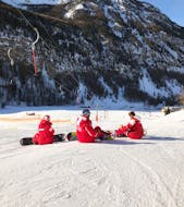 Des moniteurs de l'ESF Ceillac font une pause sur les pistes pendant un cours de snowboard pour débutants. 