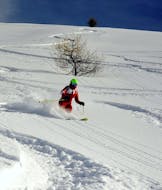 An instructor of the ski school ESF Ceillac skiing through a field of powder snow during private ski lessons for adults.