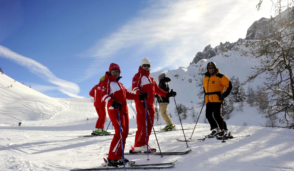 A group of skiers and their instructors take a break during private ski lessons for adults with the ski school ESF Ceillac. 