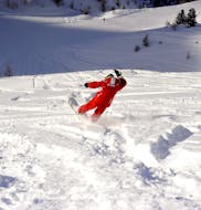 An instructor from the ski school ESF Ceillac shows how to snowboard in powder snow during private snowboarding lessons for all levels. 