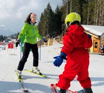 Een kind met een van de skileraren tijdens een van de privé-skilessen voor kinderen van alle niveaus in Alleghe.