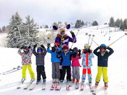 A group of children have fun with their instructor during their kids ski lessons for all levels with the PDS Snowsports ski school.