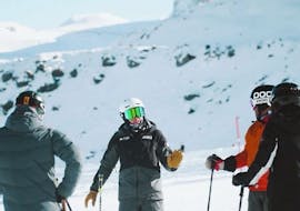 Volwassenen luisteren aandachtig naar hun instructeur tijdens hun skilessen voor volwassenen bij PDS Snowsports skischool.
