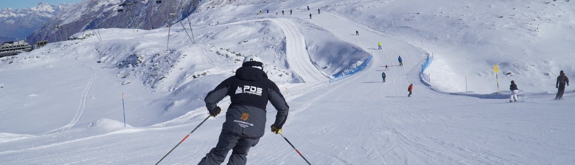 Uno sciatore gareggia in discesa durante le lezioni private di sci per adulti con la scuola di sci PDS Snowsports.