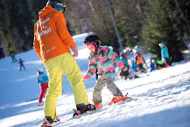 Ein Skilehrer von Skipoint Szklarska Poreba hilft einem Kind während eines privaten Skikurses für Kinder aller Levels mit Skipoint Szklarska Poręba.