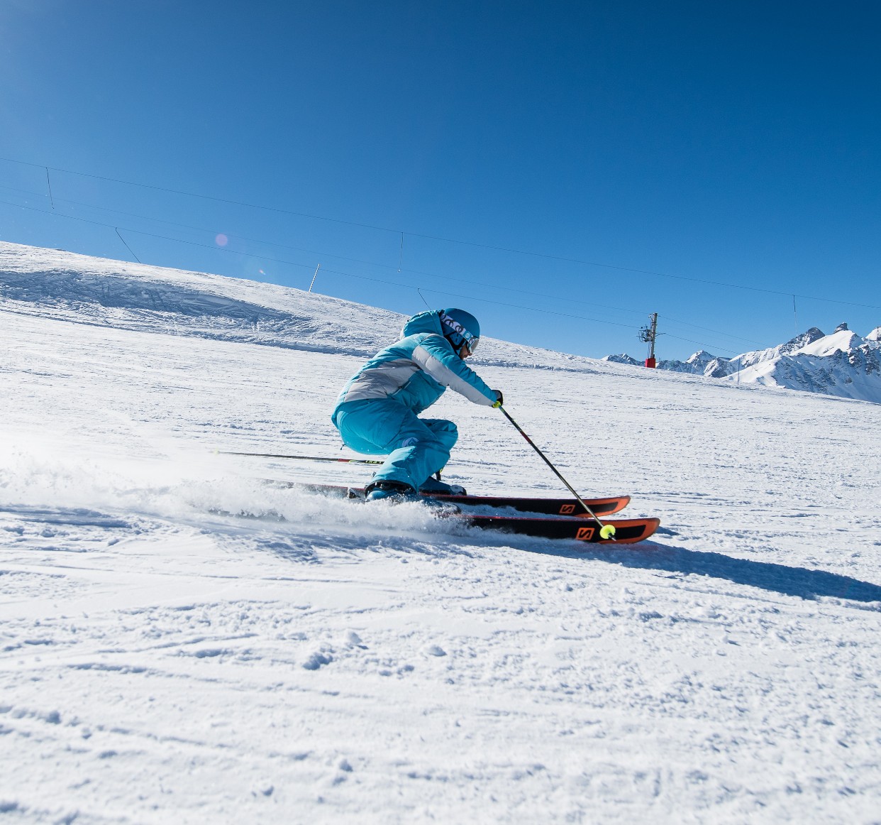 An instructor from the ski school ESI Ski Family demonstrates carving on the slopes of Grand Bornand during private ski lessons for adults. 