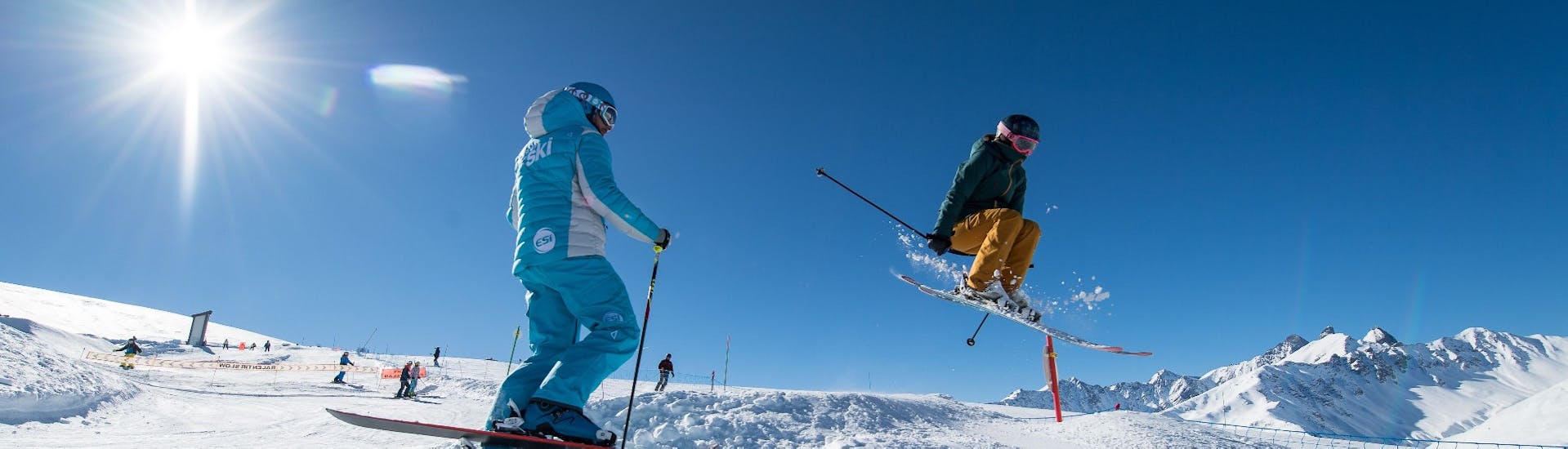 A skier practices freestyle with his  instructor of the ski school ESI Ski Family during private ski lessons for adults in Grand Bornand.