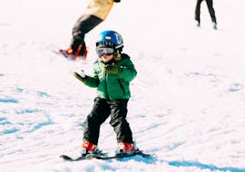 A small child learning how to ski during Kids Ski Lessons (from 7 y.) for Beginners with Native Snowsports Oberwiesenthal.