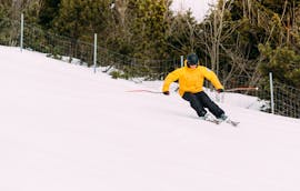 Ein Skifahrer fährt die Pisten hinunter während des Skikurses für Erwachsene für Anfänger mit Native Snowsports Oberwiesenthal.