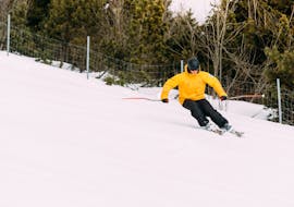 Ein Skifahrer fährt die Pisten hinunter während des Skikurses für Erwachsene für Anfänger mit Native Snowsports Oberwiesenthal. 
