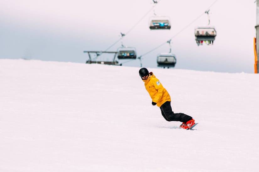 Een instructeur die laat zien hoe je moet snowboarden tijdens snowboardlessen voor kinderen en volwassenen voor beginners bij Native Snowsports Oberwiesenthal.