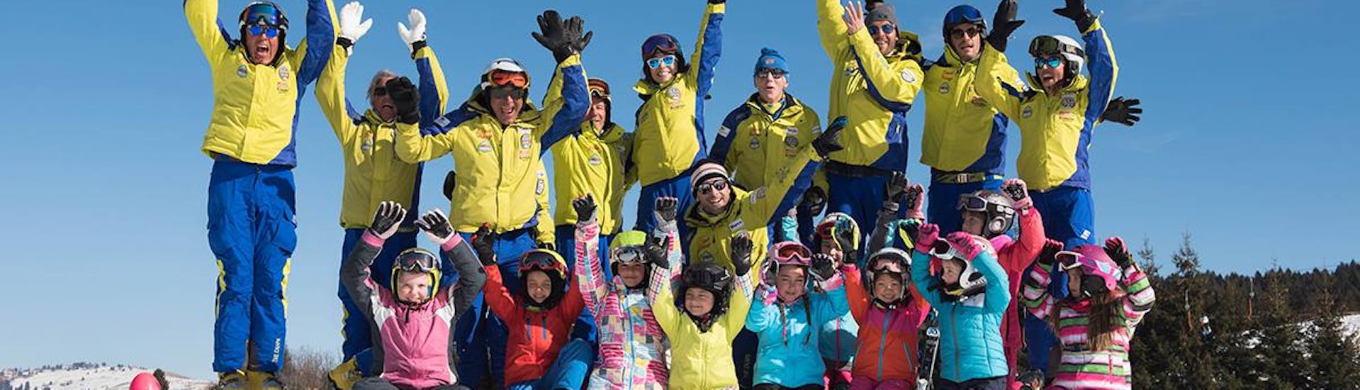 Tutti sono felici durante una delle lezioni di sci per bambini di tutti i livelli ad Asiago. 