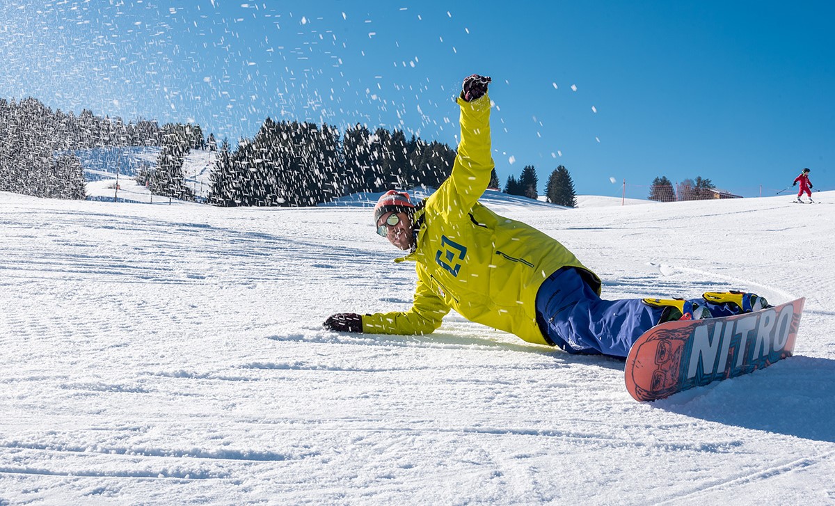 Snowboard instructor flexing on the slopes of Asiago before one of the private snowboarding lessons for kids and adults. 