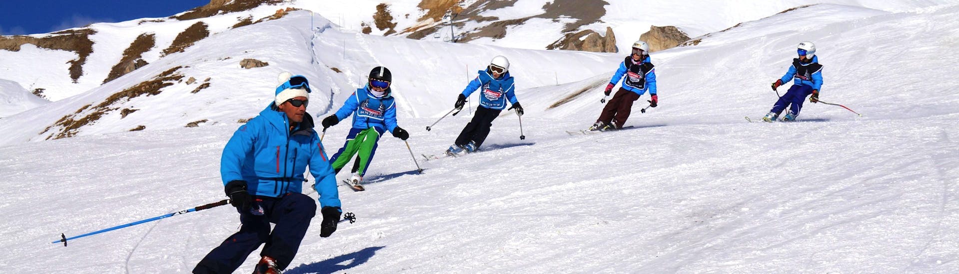 Junge Skifahrer folgen ihrem Skilehrer von der Skischule Snocool in Sainte-Foy-Tarentaise auf einer verschneiten Piste während ihres Kinderskikurses "Pop 6" (10-17 Jahre) - Fortgeschrittene. 