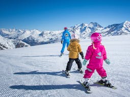 2 little kids are learning how to ski during kids ski lessons "super minis" with Ski School ESKIMOS Saas-Fee.