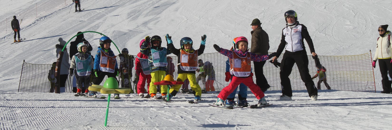 Bambini che si divertono durante le lezioni di sci per bambini (4-6 anni) per principianti con la Giorgio Rocca Ski Academy a Crans-Montana.