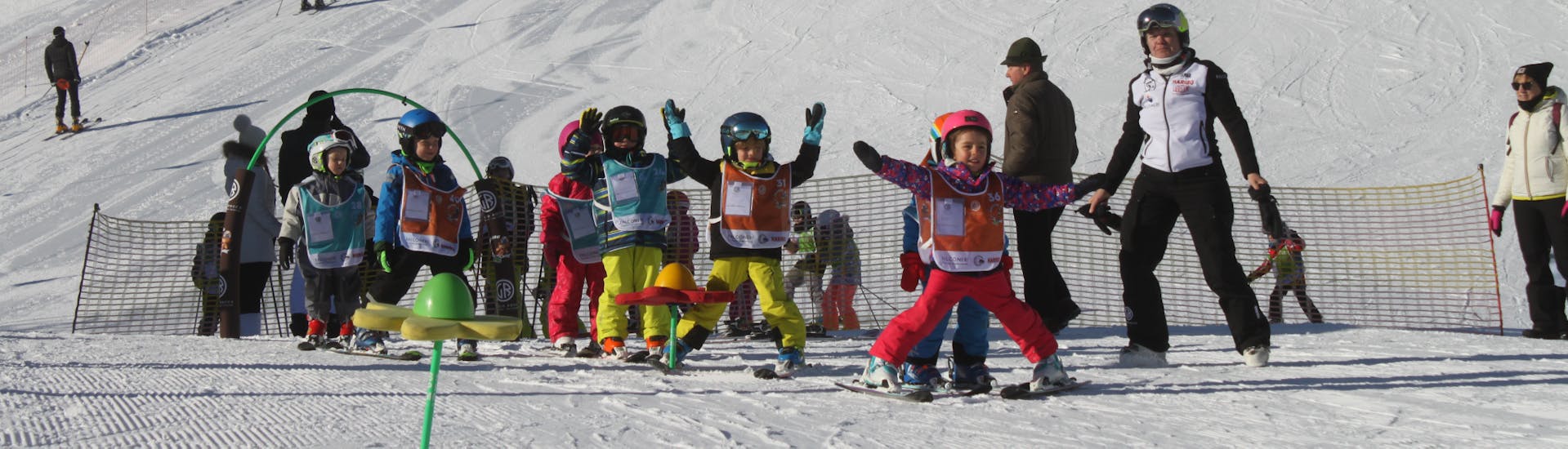 Des enfant s'amusent pendant un cours de ski enfants (4-6 ans) pour débutants avec la Giorgio Rocca Ski Academy de Crans-Montana.