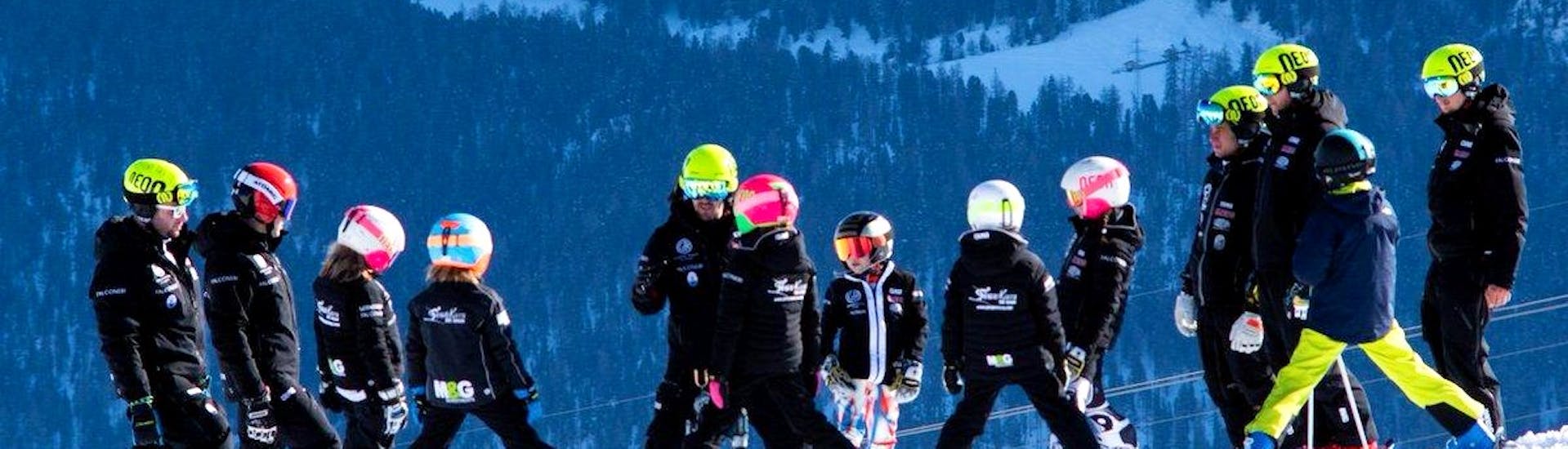 Skiërs maken zich klaar om de piste op te gaan tijdens skilessen voor kinderen voor ervaren skiërs met Giorgio Rocca Ski Academy in Crans-Montana.