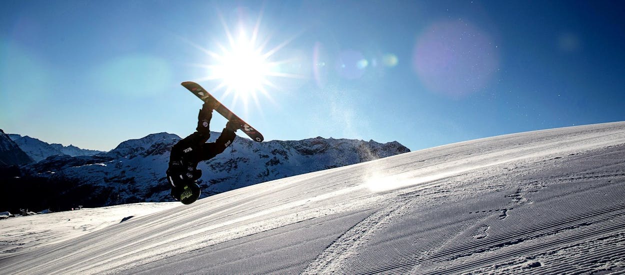 Un istruttore della Giorgio Rocca Ski Academy esegue trucchi di snowboard sulle piste di Crans-Montana durante le lezioni private di snowboard per tutti i livelli.