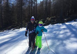 Ein Skilehrer und ein Kind sind bereit für den privaten Kinderskikurs für alle Levels in Madonna di Campiglio.
