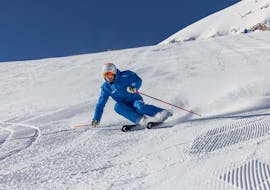 A skier from Skipower Finkenberg ski school races down the slopes in Finkenberg during his private ski lessons for adults for all levels. 