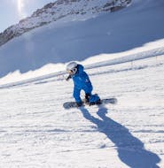 Ein Snowboardlehrer der Skischule Skipower Finkenberg fährt während einem privaten Snowboardkurs für Kinder und Erwachsene die Piste hinunter.
