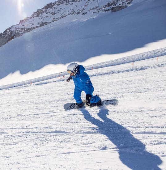 Een snowboardleraar van de skischool Skipower Finkenberg rijdt de piste af tijdens een privé snowboardles voor kinderen en volwassenen.