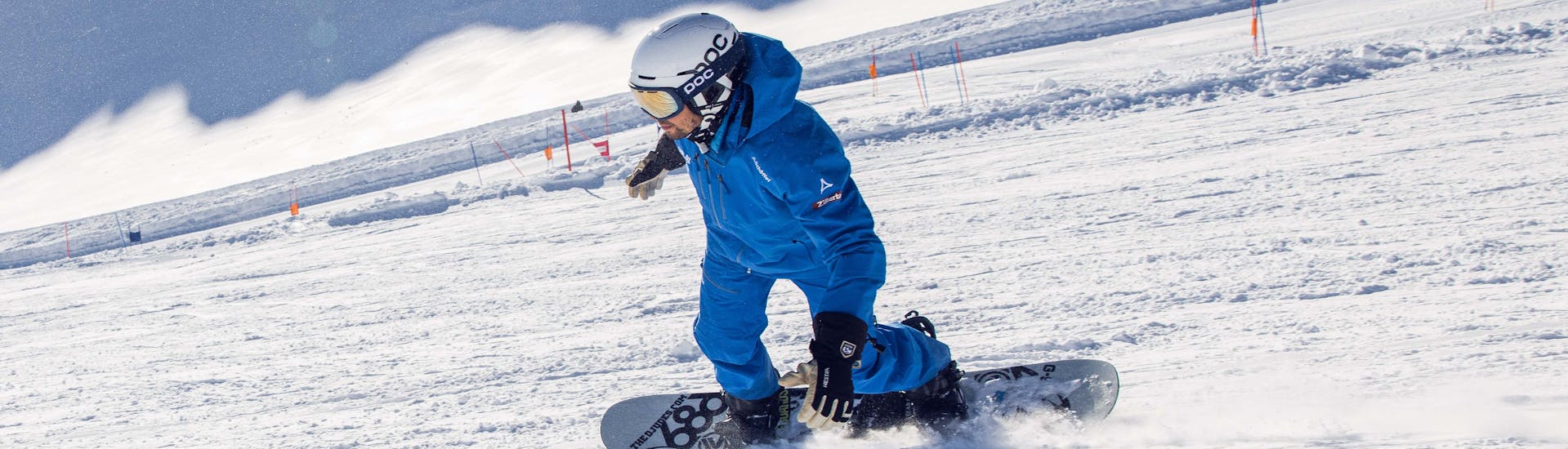 Een snowboardleraar van de skischool Skipower Finkenberg rijdt de piste af tijdens een privé snowboardles voor kinderen en volwassenen.