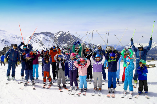 A group of children have fun with their instructor during their kids ski lessons for all levels with the PDS Snowsports ski school in Champéry.