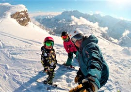 Een skileraar van de PDS Snowsports skischool met twee kleine skiërs tijdens hun privé kinderskilessen.