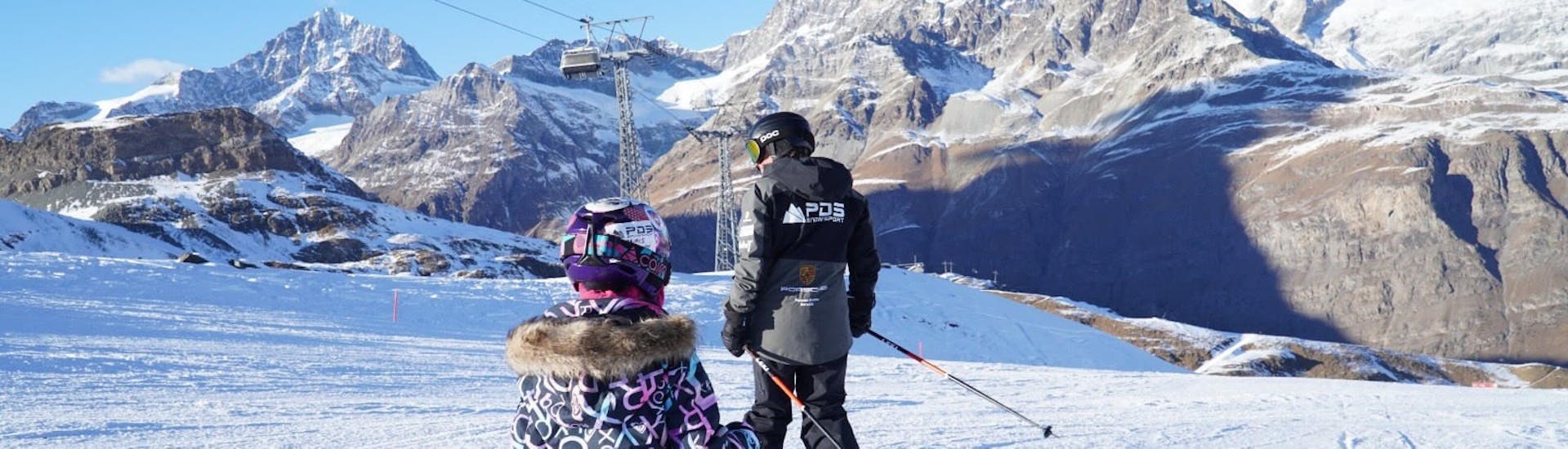 Two little skiers follow their instructor from the PDS Snowsports ski school during kids ski lessons in Champéry. 