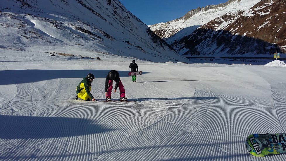 Een snowboardleraar van de skischool Snowlimit Andermatt laat zijn leerlingen verschillende oefeningen zien tijdens een snowboardles voor kinderen.