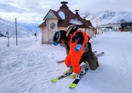 Un maestro di sci della scuola Snowlimit Andermatt aiuta un piccolo sciatore durante le sue lezioni private di sci per bambini e ragazzi.