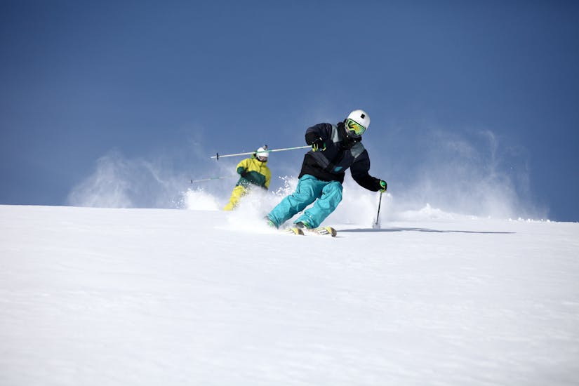 A skier follows his instructor from the Snowlimit Andermatt ski school during his private ski lessons for adults.