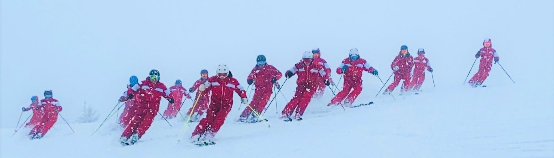 A group of ski instructors from the Schneesportschule Oberndorf ski down the slopes during a ski lesson for teens of all levels. 