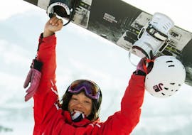 Een snowboarder beleeft plezier in de sneeuw tijdens haar snowboardlessen voor kinderen en volwassenen voor alle niveaus met de Schneesportschule Oberndorf.