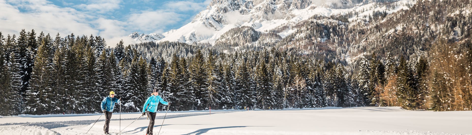 Twee langlaufers genieten van de natuur tijdens de langlauflessen voor alle niveaus met de Schneesportschule Oberndorf.