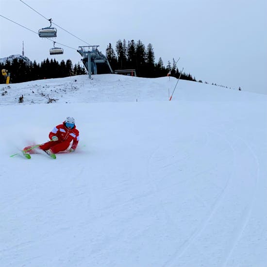 Een skiër racet de helling af tijdens zijn privé Race & Fun-lessen bij de Schneesportschule Oberndorf.