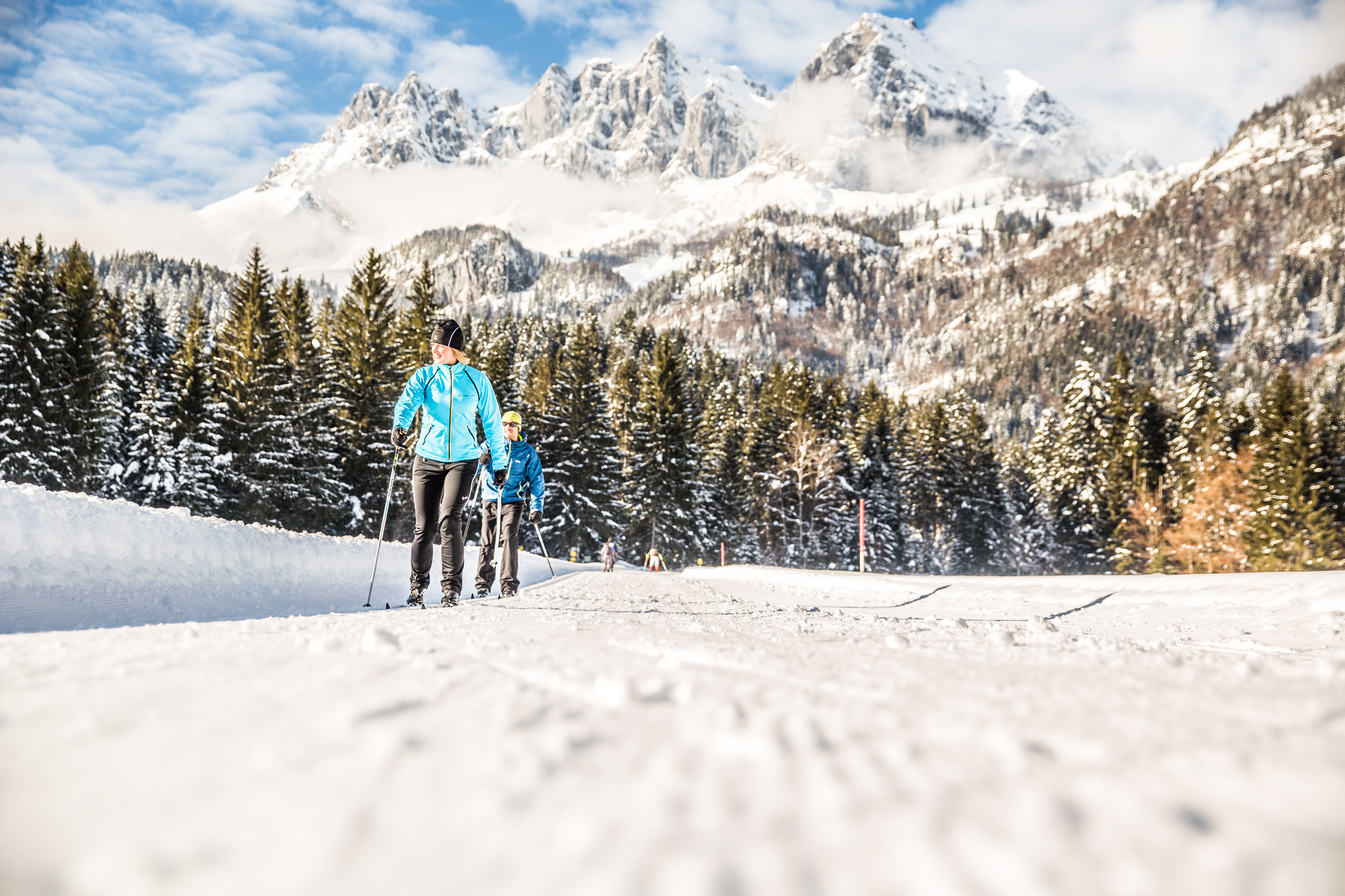 Two cross-country skiers enjoy the fresh air and nature during their private cross-country skiing lessons with the Schneesportschule Oberndorf. 