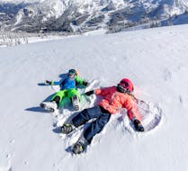 Two children have fun in the snow during their private ski lesson for kids of all ages with the Nassfeld Ski School.