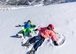 Two children have fun in the snow during their private ski lesson for kids of all ages with the Nassfeld Ski School.