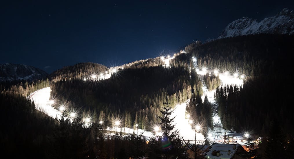 Incredibile vista notturna sulle piste di Pecol, il luogo perfetto per una delle lezioni private di sci per adolescenti e adulti - sci notturno.