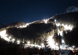 Incredibile vista notturna sulle piste di Pecol, il luogo perfetto per una delle lezioni private di sci per adolescenti e adulti - sci notturno.
