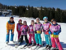 A group of skiers have fun in the snow during their kids ski lessons for people with experience with the Thommi Ski School in Nassfeld.