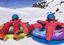 Twee kinderen vermaken zich in de sneeuw tijdens hun kinderskiles bij de Alpine Skischool Edelweiss Kirchberg.