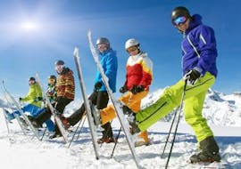 Een groep skiërs heeft plezier in de sneeuw tijdens de skilessen voor volwassenen voor beginners bij de Alpine Skischool Edelweiss.